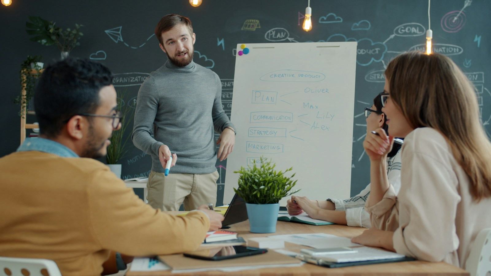 Equipo de liderazgo revisando un plan frente a una pizarra